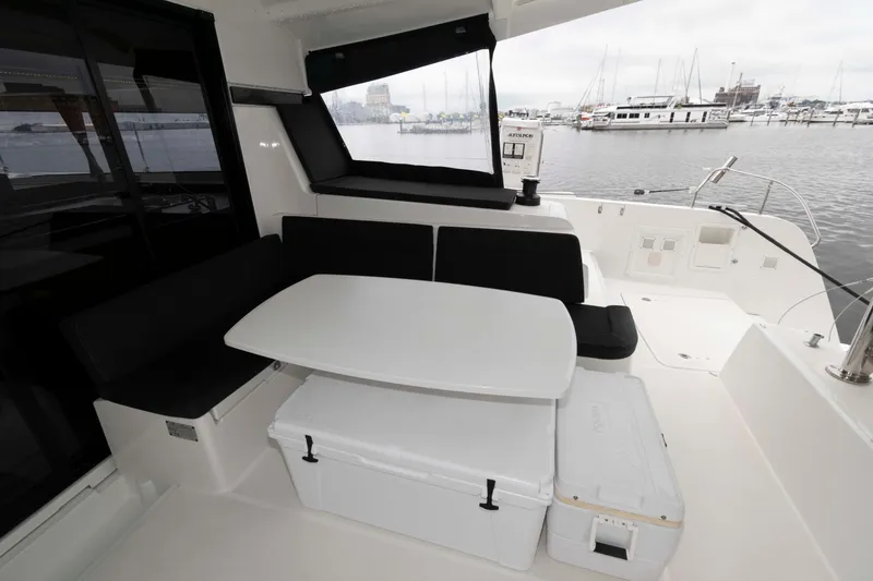Slide: The Image of 2019 Lagoon 42 yacht cockpit with seating and table, overlooking marina. - 8