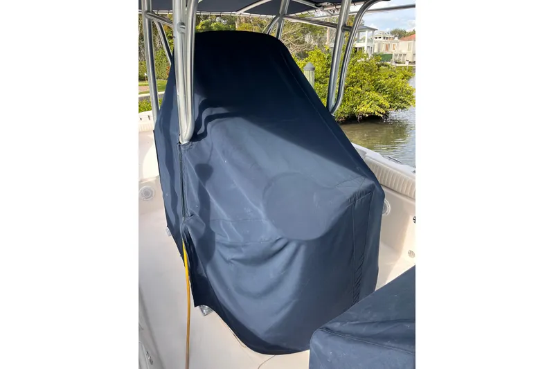 Slide: The Image of 2006 Grady-White Release 283 boat with covered console, docked near lush greenery. - 11