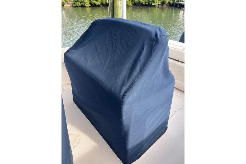 Slide: The Image of Blue-covered console on 2006 Grady-White Release 283 boat, docked by water. - 12