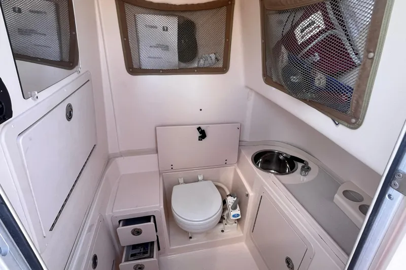 Slide: The Image of 2006 Grady-White Release 283 boat interior with toilet, sink, and storage compartments. - 17