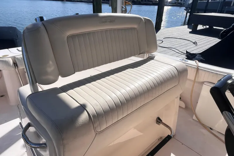 Slide: The Image of 2006 Grady-White Release 283 boat seat, white leather, docked by the water. - 28