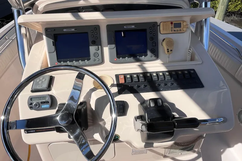 Slide: The Image of 2006 Grady-White Release 283 boat dashboard with steering wheel and navigation controls. - 30