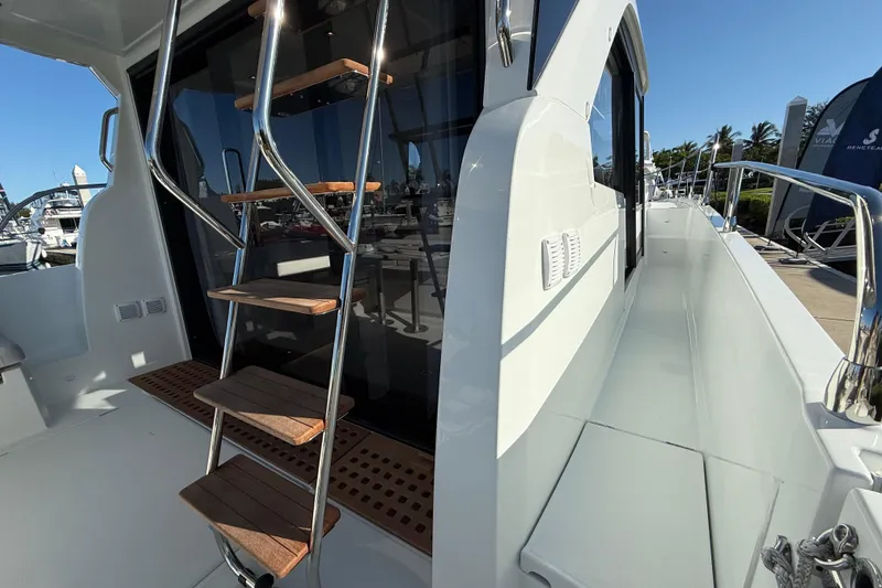 Slide: The Image of 2026 Beneteau Antares 12 yacht with sleek design, featuring a wooden ladder and spacious deck. - 12