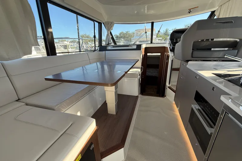 Slide: The Image of Interior of 2026 Beneteau Antares 12 yacht with modern seating and kitchen area. - 23