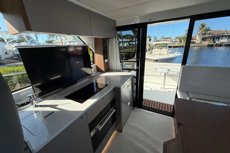 Slide: The Image of Interior of 2026 Beneteau Antares 12 yacht with modern kitchen and waterfront view. - 24