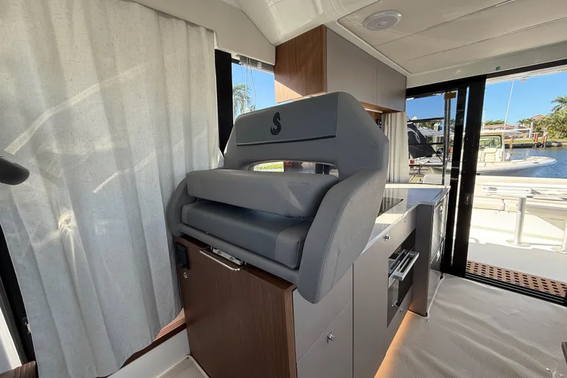 Slide: The Image of Interior of 2026 Beneteau Antares 12 yacht with modern helm seat and kitchenette. - 28