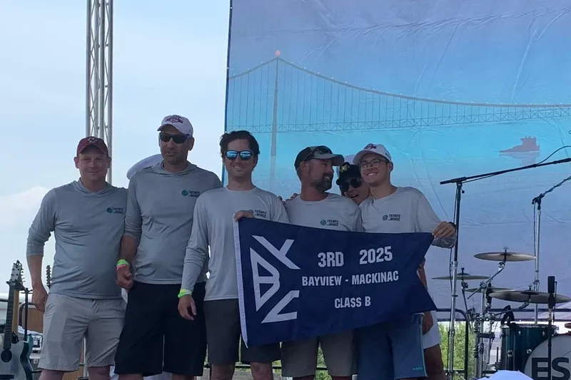 Slide: The Image of Group celebrating 3rd place in 2025 Bayview Mackinac Class B race, holding a banner. - 11