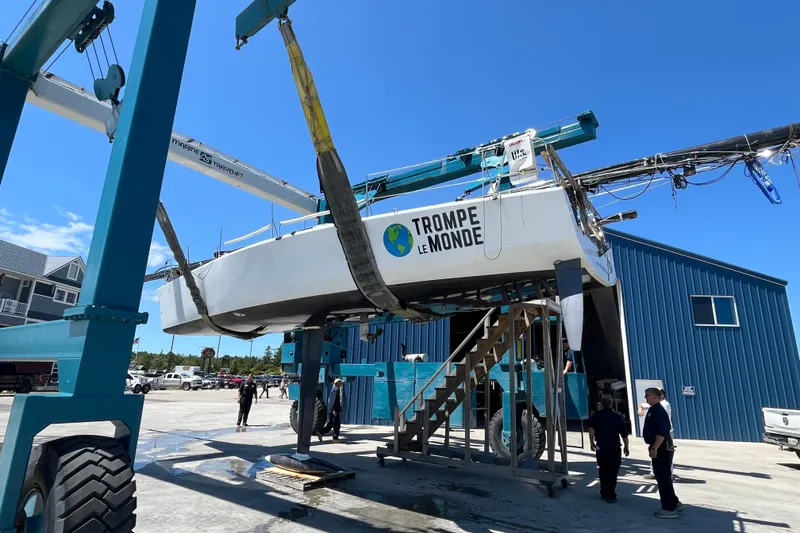 Slide: The Image of Farr 11s sailboat from 2009, named "Trompe Le Monde," lifted by a marine travel lift. - 9