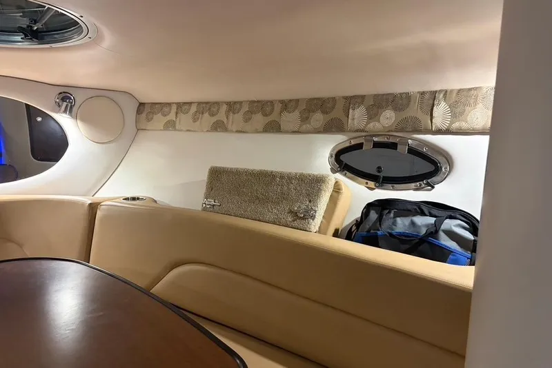 Slide: The Image of Interior of 2019 Crownline 264 CR boat with beige seating and porthole window. - 15