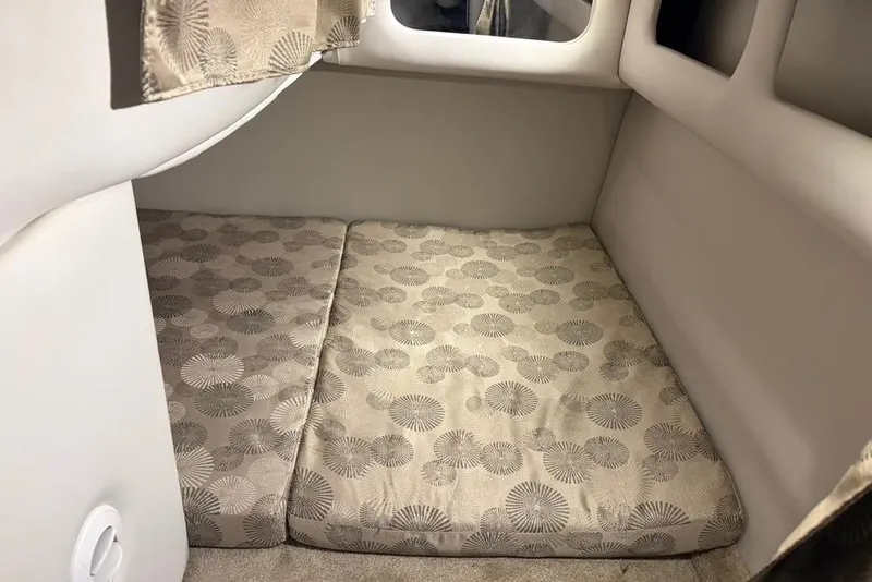 Slide: The Image of 2019 Crownline 264 CR cabin interior with patterned cushions and soft lighting. - 19