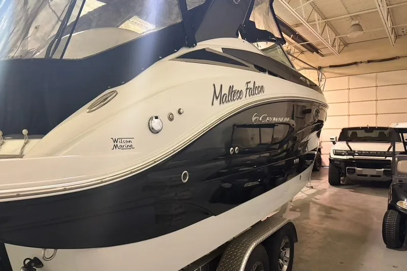Slide: The Image of 2019 Crownline 264 CR boat named "Maltese Falcon" in a garage with vehicles. - 3