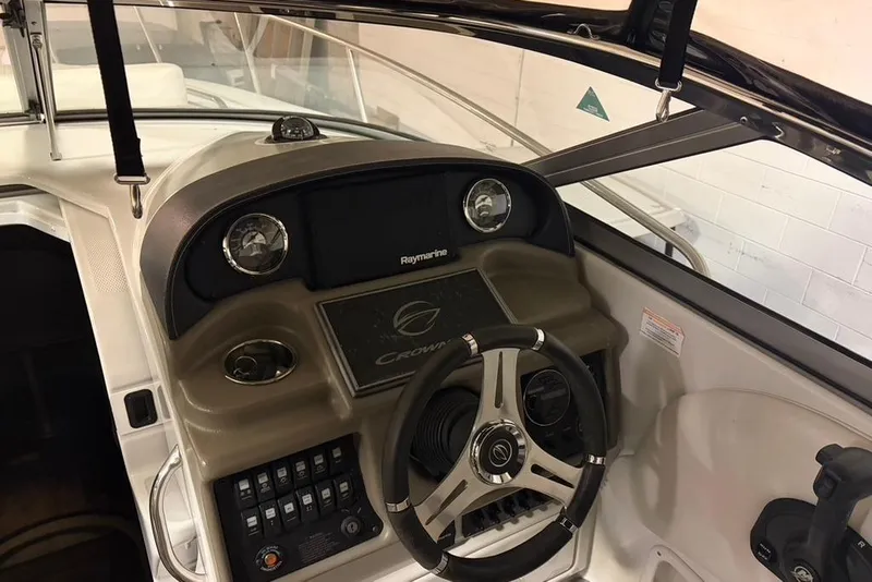 Slide: The Image of 2019 Crownline 264 CR boat dashboard with steering wheel and control panel. - 8