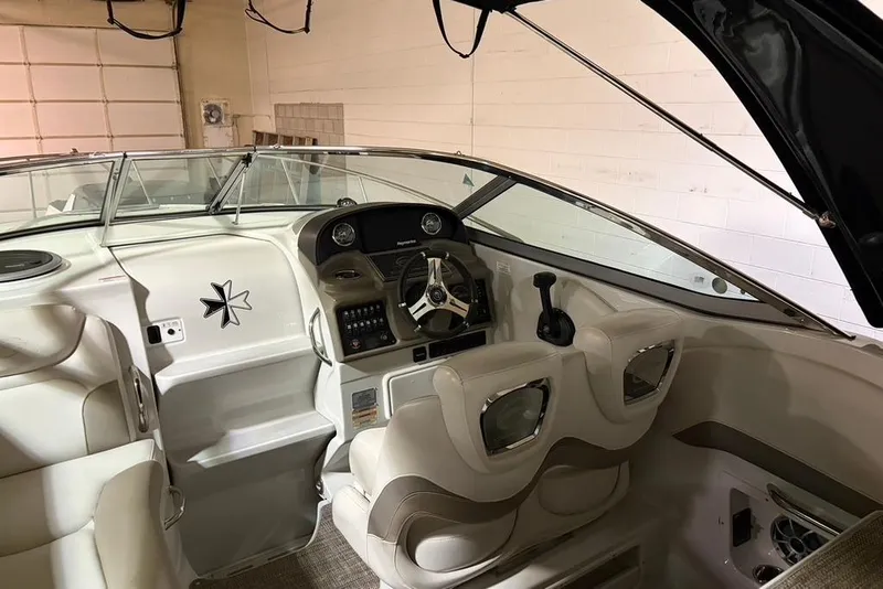 Slide: The Image of 2019 Crownline 264 CR boat interior with steering wheel and seating in a garage. - 9