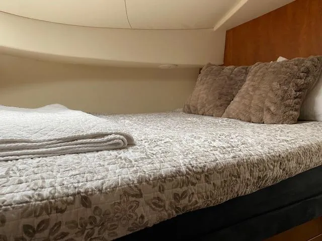 Slide: The Image of Cozy bedroom in 2007 Silverton 33 Convertible boat with plush pillows and floral bedding. - 16