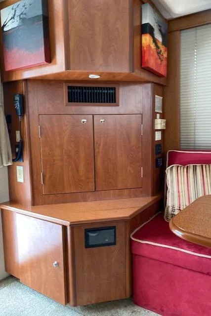 Slide: The Image of Interior of a 2007 Silverton 33 Convertible boat with wooden cabinetry and red seating. - 25