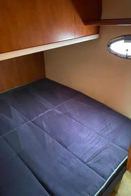 Slide: The Image of 2007 Silverton 33 Convertible cabin with bed and porthole window. - 33