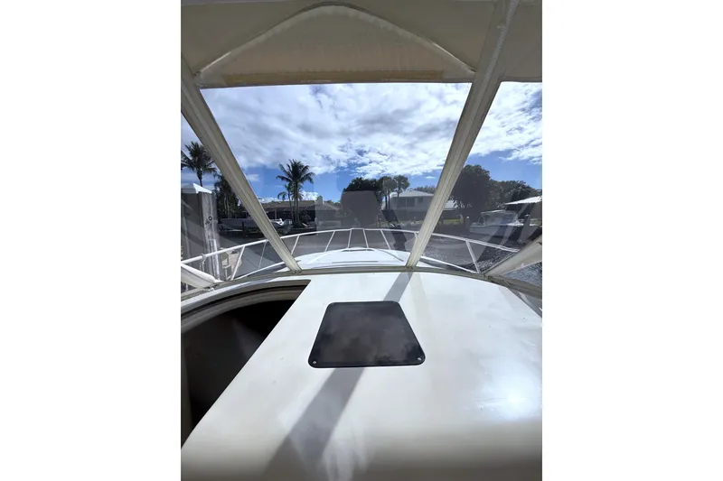 Slide: The Image of 2004 Intrepid 377 Walkaround boat with clear canopy and scenic view. - 13