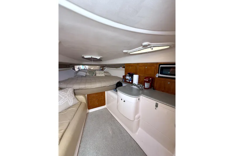 Slide: The Image of 2004 Intrepid 377 Walkaround cabin interior with bed, kitchenette, and seating area. - 16