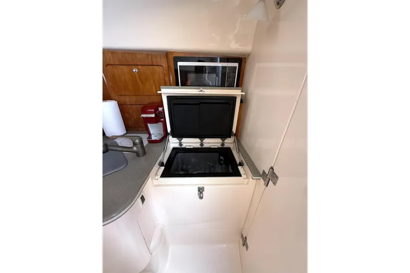 Slide: The Image of 2004 Intrepid 377 Walkaround interior kitchen with sink, microwave, and storage. - 18
