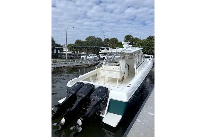 Slide: The Image of 2004 Intrepid 377 Walkaround boat docked with triple outboard engines. - 25