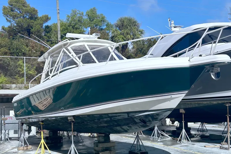 Slide: The Image of 2004 Intrepid 377 Walkaround boat on stands, green hull, outdoor storage. - 27