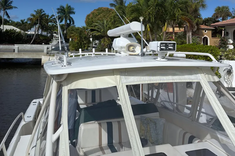 Slide: The Image of 2004 Intrepid 377 Walkaround boat docked near tropical waterfront homes. - 4