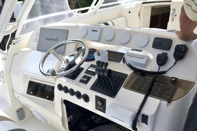 Slide: The Image of 2004 Intrepid 377 Walkaround helm with Garmin and Simrad electronics, steering wheel, and controls. - 9