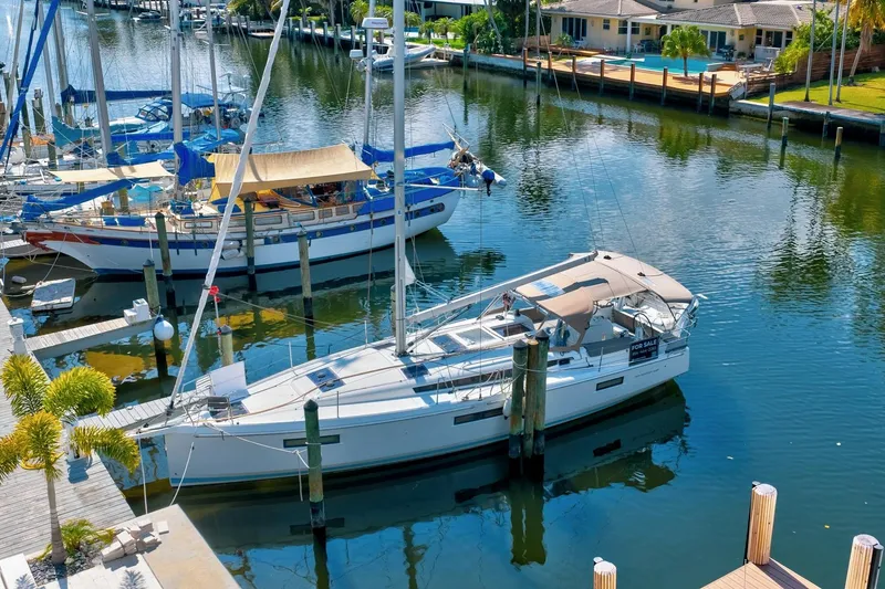 The Image of 2021 Jeanneau Sun Odyssey 440 sailboat docked in a serene marina setting. - 0