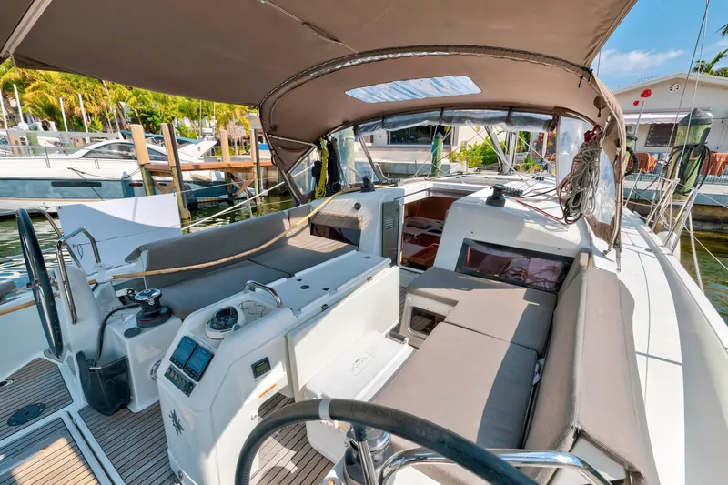 Slide: The Image of 2021 Jeanneau Sun Odyssey 440 sailboat cockpit with canopy, docked in a marina. - 11