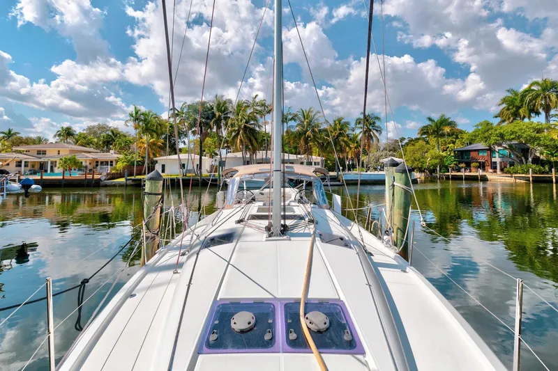 Slide: The Image of 2021 Jeanneau Sun Odyssey 440 sailboat docked in a tropical marina with palm trees. - 18