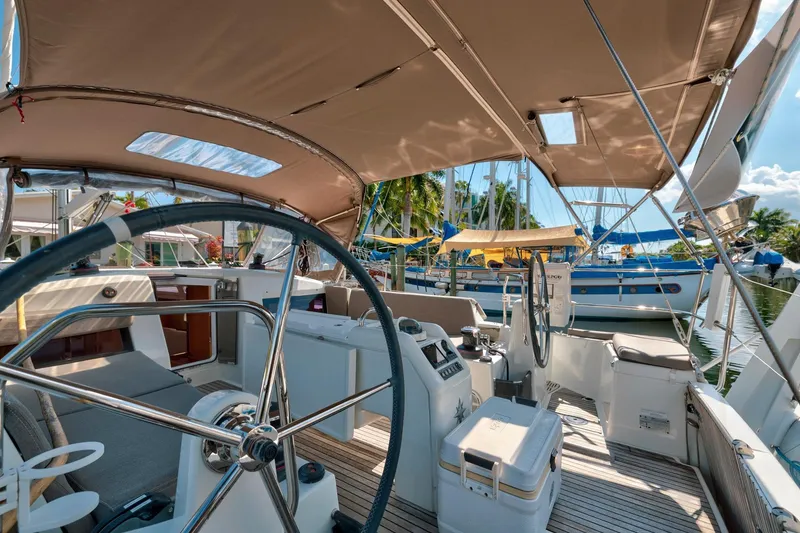 Slide: The Image of 2021 Jeanneau Sun Odyssey 440 yacht interior with steering wheel and canopy, docked at marina. - 28