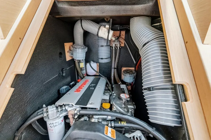 Slide: The Image of Engine compartment of 2021 Jeanneau Sun Odyssey 440 sailboat, showcasing mechanical components and ventilation. - 48