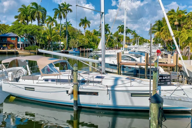Slide: The Image of 2021 Jeanneau Sun Odyssey 440 sailboat docked, surrounded by palm trees and clear skies. - 5