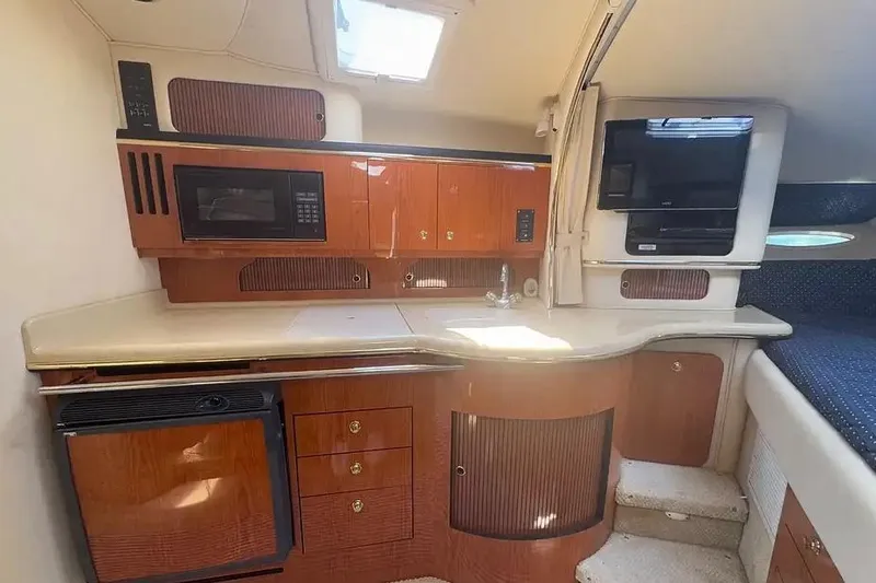 Slide: The Image of 2001 Sea Ray Sundancer 310 interior with kitchenette, microwave, and TV. - 10