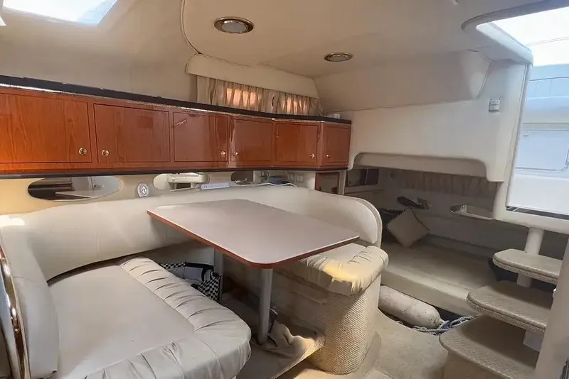 Slide: The Image of 2001 Sea Ray Sundancer 310 cabin interior with dining area and wooden cabinets. - 6