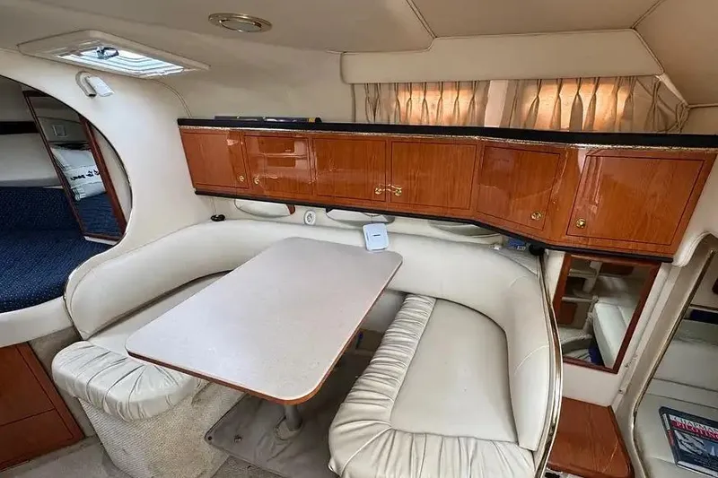 Slide: The Image of Interior of 2001 Sea Ray Sundancer 310, featuring a cozy dining area with wooden cabinetry. - 8