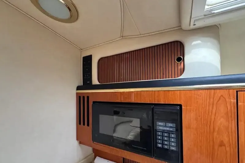 Slide: The Image of 2001 Sea Ray Sundancer 310 interior with microwave and wooden cabinetry. - 9