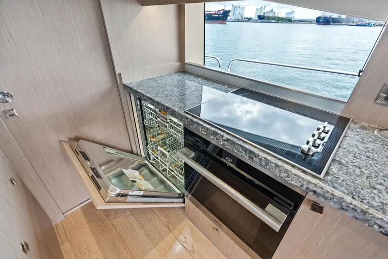 Slide: The Image of Modern kitchen on 2019 Sunseeker 86 Yacht with open dishwasher and stovetop. - 15