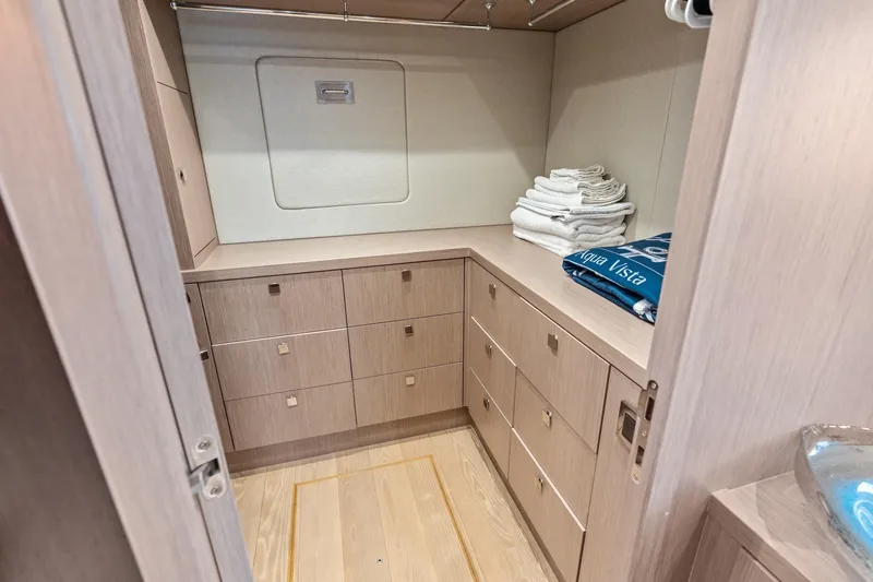 Slide: The Image of Luxurious storage area on 2019 Sunseeker 86 Yacht with wooden cabinetry and neatly stacked towels. - 24
