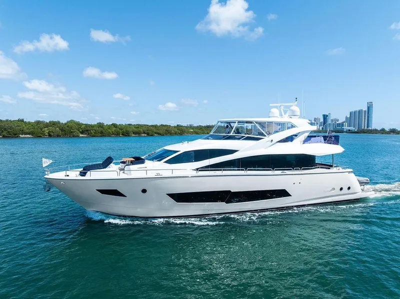 Slide: The Image of Luxurious 2019 Sunseeker 86 Yacht cruising on serene waters near waterfront homes. - 6