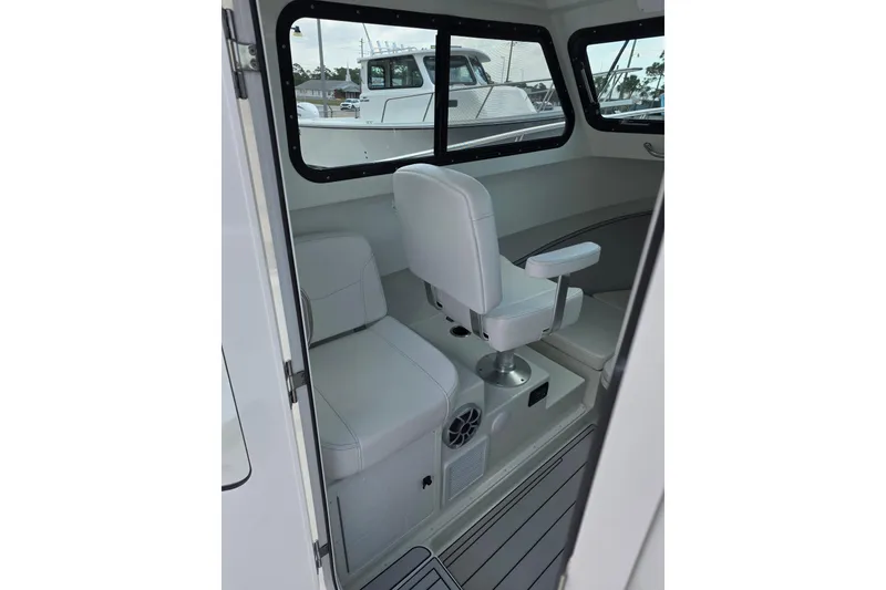 Slide: The Image of Interior of 2026 Parker 247 Explorer boat with white seating and windows. - 16