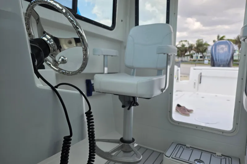 Slide: The Image of Interior of 2026 Parker 247 Explorer boat with steering wheel and captain's chair. - 19