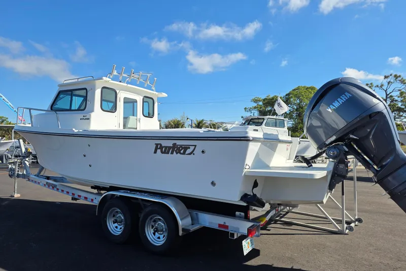 Slide: The Image of 2026 Parker 247 Explorer boat on trailer with Yamaha outboard motor, parked outdoors. - 5