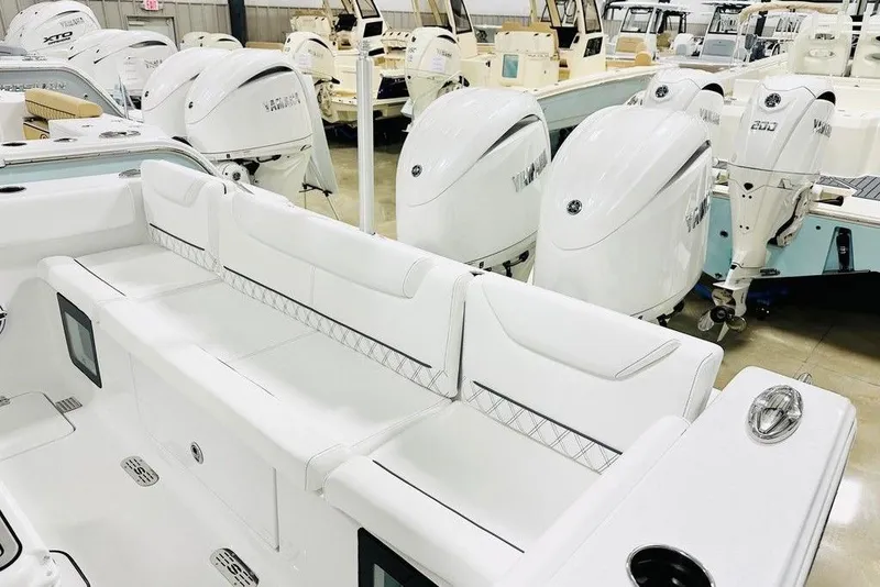 Slide: The Image of 2026 Sportsman Heritage 261 Center Console boat interior with white seating and multiple outboard engines. - 12