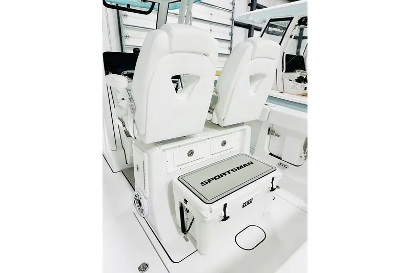 Slide: The Image of 2026 Sportsman Heritage 261 Center Console boat interior with white seating and storage. - 7