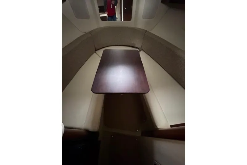 Slide: The Image of Interior of 2018 Sea Ray Sundancer 260 with cushioned seating and wooden table. - 13