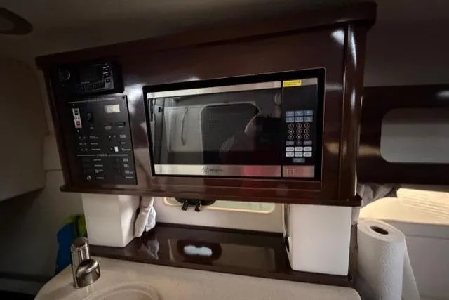 Slide: The Image of Interior of 2018 Sea Ray Sundancer 260 featuring a built-in microwave and control panel. - 14