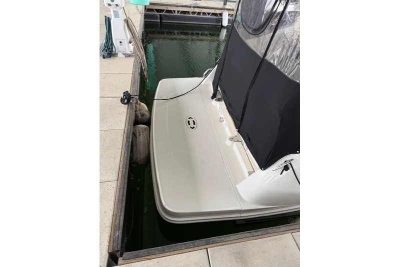 Slide: The Image of 2018 Sea Ray Sundancer 260 docked, rear view with black canopy, in marina. - 22