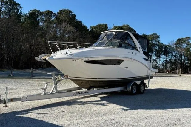 Slide: The Image of 2018 Sea Ray Sundancer 260 boat on trailer, parked outdoors under clear blue sky. - 5