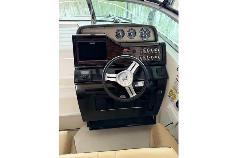 Slide: The Image of 2018 Sea Ray Sundancer 260 helm with steering wheel, gauges, and control panel. - 7